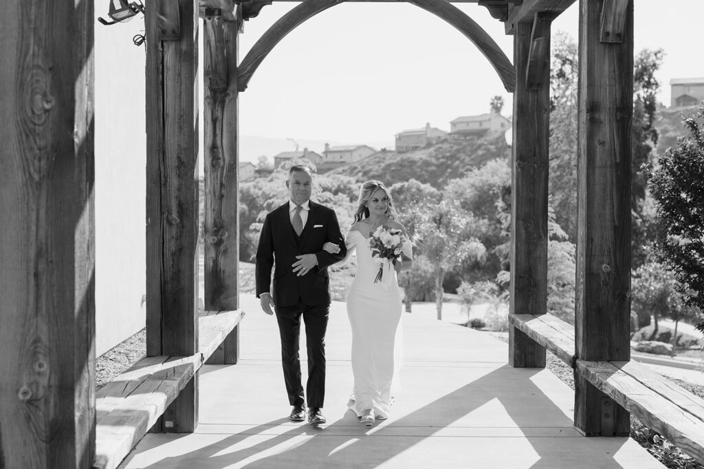 bride walking to the ceremony with her father at The Lambs Fellowship
